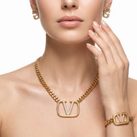 Model draagt de gouden V-logo set met kristallen van Nana Boutique Jewellery